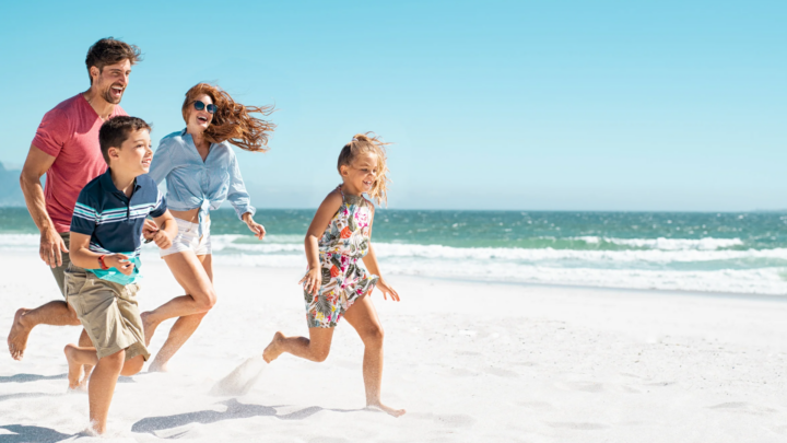 Family running and laughing on the beach, enjoying quality time and emotional connection.