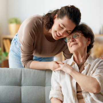 Caregiver fatigue shown with woman leaning on elderly parent.